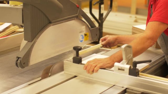 carpenter with panel saw and fibreboard at factory