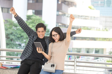 Portrait of Attractive Asian Student Pople standing at outdoor place. People holding tablet together with Education Concept.