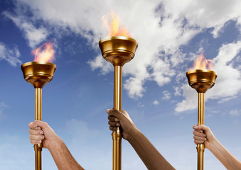 Hands holding flaming batons © Image Source RF