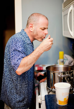 Man Tasting Food And Cooking