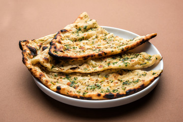 Garlic and coriander naan served in a plate, it's a type of Indian bread or roti flavoured with garlic
