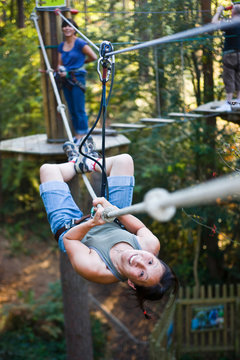 Woman Climbing Highwire In Forest