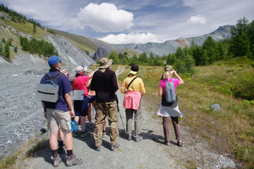Fototapeta na wymiar Group of people hikers with backpacks standing and looking at the mountains at sunny day Altai Mountains Siberia, Russia