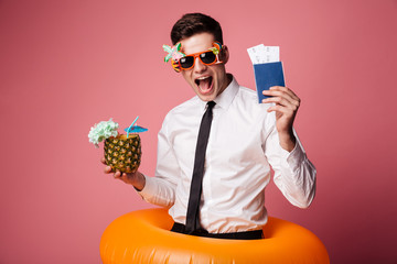 Happy man in sunglasses and official shirt showing cocktail and international passport