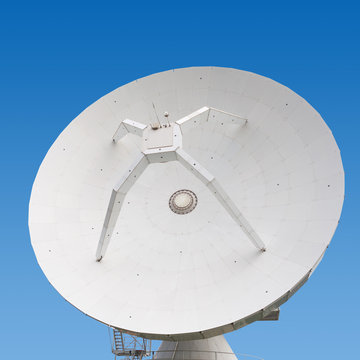 Big parabolic antenna at a day time with blue sky on background