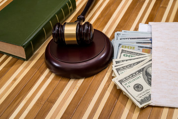 wooden gavel with dollar banknote on desk
