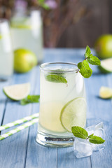 Lime and lemon lemonade with mint on the blue background