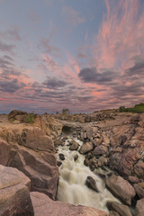 Landscape of the Augrabies Waterfall at sunset and pink clouds