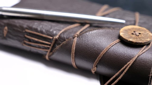 Close up dollu shot on leather vintage retro notebook on a dark table. Old type diary