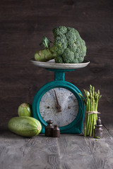 Fresh vegetables on the old vintage scales on wooden background