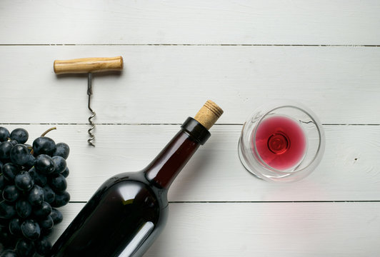 Red wine bottle on a wooden white background