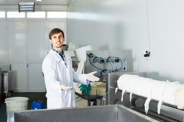 Man in lab coat at dairy production process.