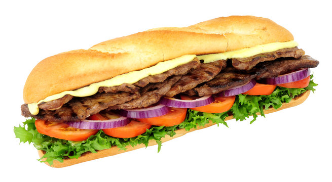 Beef steak and salad filled crusty baguette sandwich isolated on a white background