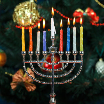 Menorah with candles for Hanukkah on the background of the New Year tree