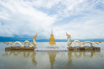 The Golden pagoda and Twin Naga an iconic landmark in Phayao lake, Thailand. (The text at the base...
