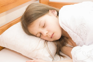 Obraz na płótnie Canvas Маленькая девочка спит в своей кровати под одеялом
