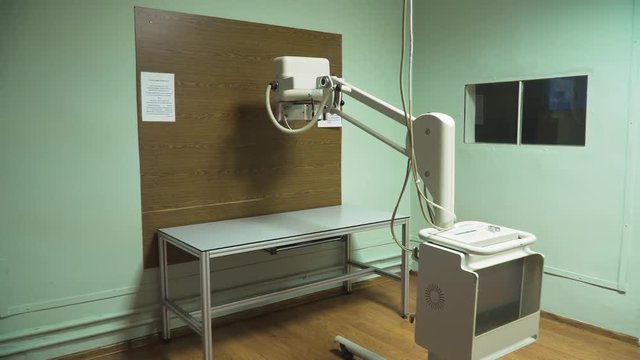 Medical office with X-ray equipment. X-ray room in a hospital ER operating room with a classic ceiling-mounted x-ray system. Modern medical equipment, interventional medicine and healthcare concept.
