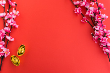 Chinese New Year Background Ornaments, Plum Flowers and Gold Ingots with Chinese Word Happiness and Prosperity. Red background.