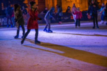 Abstract blurry background of ice skating people in city center during Christmas market