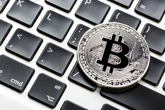 Bitcoin cryptocurrency on laptop keyboard. Close up image