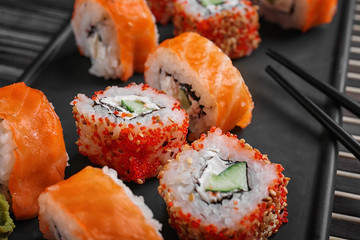 Tray with tasty sushi rolls on table, closeup