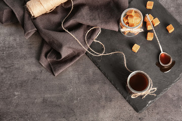Composition with tasty candies and caramel sauce on table