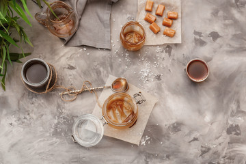 Composition with tasty candies and caramel sauce on table