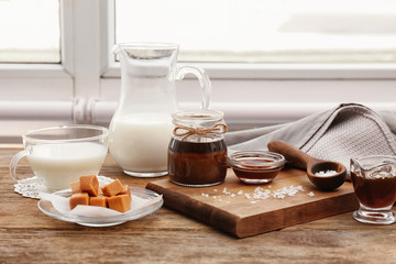 Composition with tasty candies and caramel sauce on table