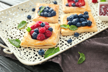 Tray with tasty berry pastries on table
