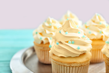 Plate with tasty cupcakes for baby shower party on table, closeup