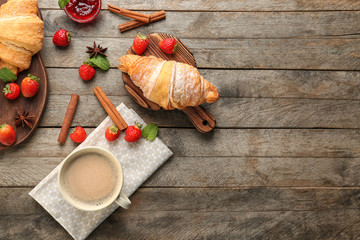 Composition with tasty croissants and coffee on wooden background