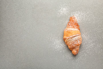 Tasty croissant on grey background