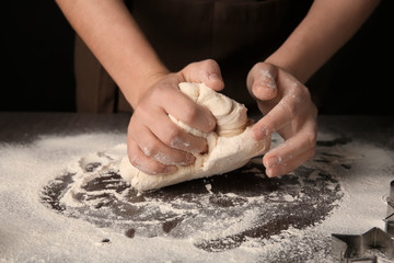 Woman kneading puff pastry on table