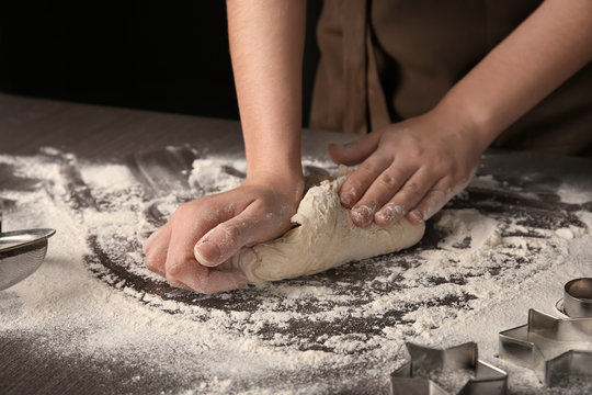 Woman kneading puff pastry on table