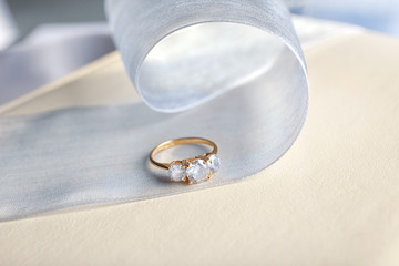 Beautiful engagement ring and ribbon on table