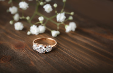 Beautiful engagement ring on wooden background