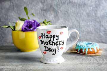 Cup with text HAPPY MOTHER'S DAY on table
