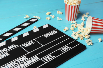 Clapperboard and popcorn on wooden background