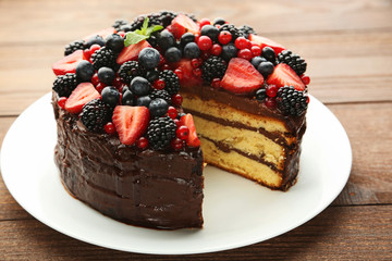 Chocolate cake with berries on brown wooden table