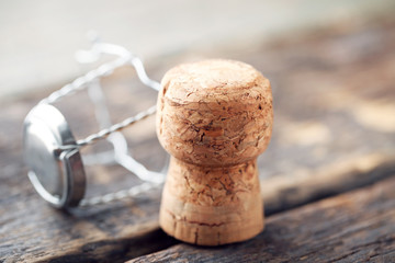 Fototapeta na wymiar Champagne cork with cap on grey wooden table