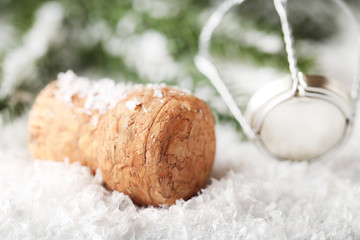 Champagne cork with cap on white snow