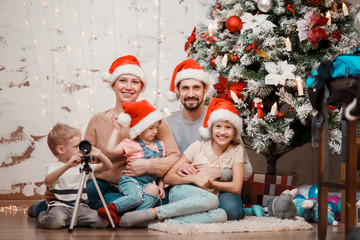 Image of parents, two daughters in caps of Santa and son with telescope