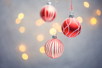 Photo of three Christmas tree red balls with pattern on gray background with hot lights.