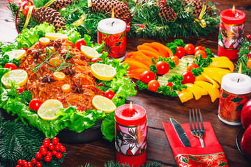 Christmas table dinner time with roasted meats, candles and New Year décor. Background thanksgiving. The concept of a family holiday, Beautiful delicious food