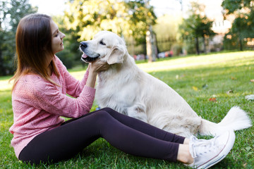 Picture of brunette hugging labrador on lawn