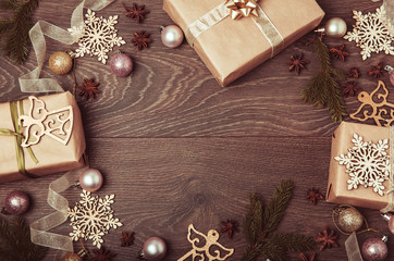 Christmas holiday composition, ornament. Festive creative gold pattern, spruce branches, xmas tree, xmas golden decor holiday ball with gift and ribbon on wooden brown background. Flat lay, top view