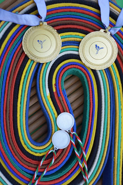 Karate belts on bamboo cane background with medals