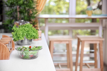 Bowl with tasty vegetable salad in modern kitchen