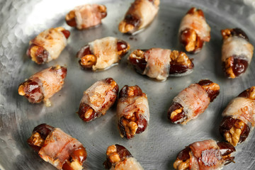 Bacon wrapped dates in frying pan, closeup
