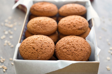 Box with delicious oatmeal cookies on table, closeup